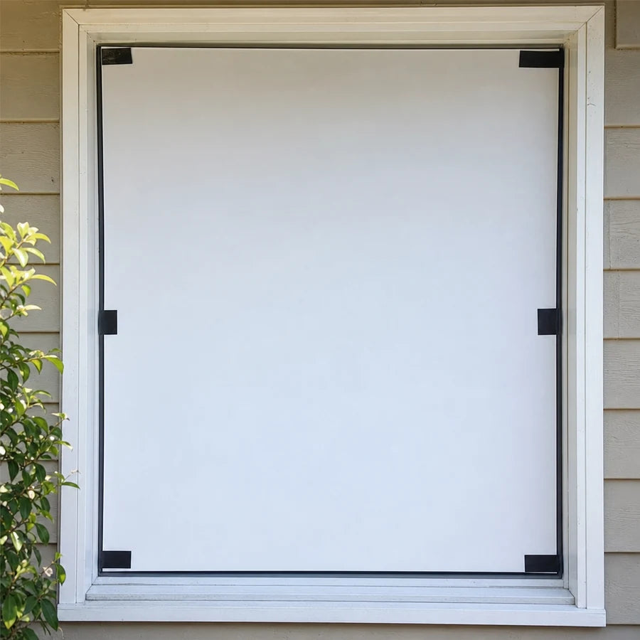 Close view of the fitted white screen taped flat inside a window frame, unlit in daylight
